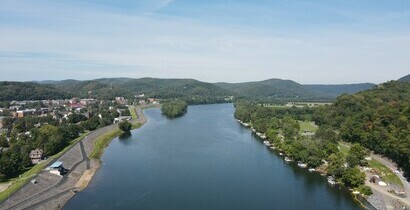 Image of the river, with the riverwalk on the left, with mountains in the background